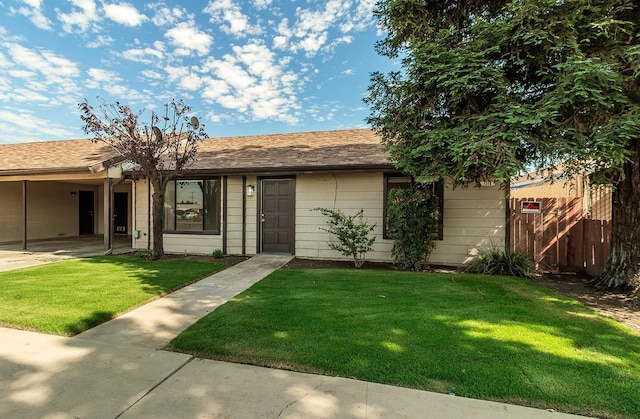 ranch-style home with a front yard and fence