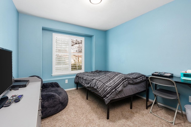 bedroom featuring light carpet and baseboards