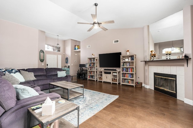 living area with visible vents, ceiling fan, dark wood-type flooring, a fireplace, and high vaulted ceiling