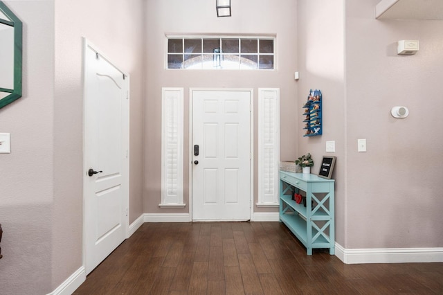 entrance foyer with dark wood-style floors and baseboards