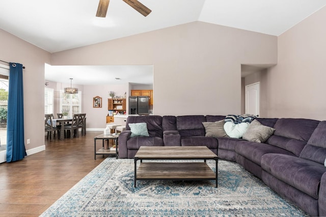 living area featuring lofted ceiling, a ceiling fan, baseboards, and wood finished floors