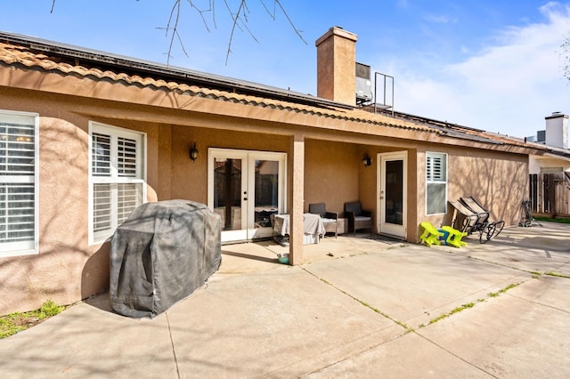 back of property with french doors and stucco siding