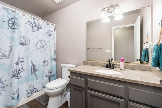 bathroom with toilet, vanity, and a shower with curtain