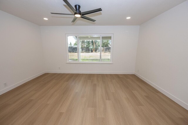 empty room with light wood-style floors, baseboards, and recessed lighting