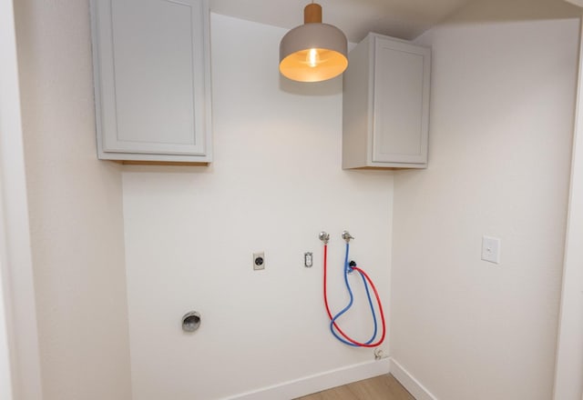 washroom with cabinet space, light wood finished floors, baseboards, hookup for an electric dryer, and washer hookup