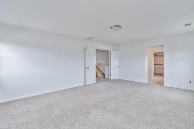 empty room with light carpet, baseboards, and visible vents