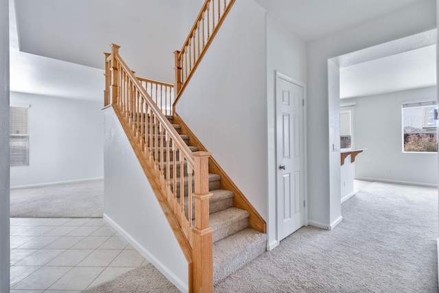 stairway featuring carpet floors, tile patterned flooring, and baseboards