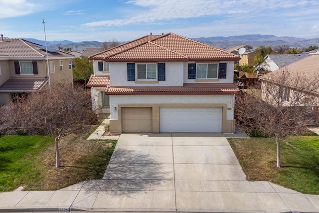 view of front of home featuring driveway, a tile roof, a mountain view, and stucco siding