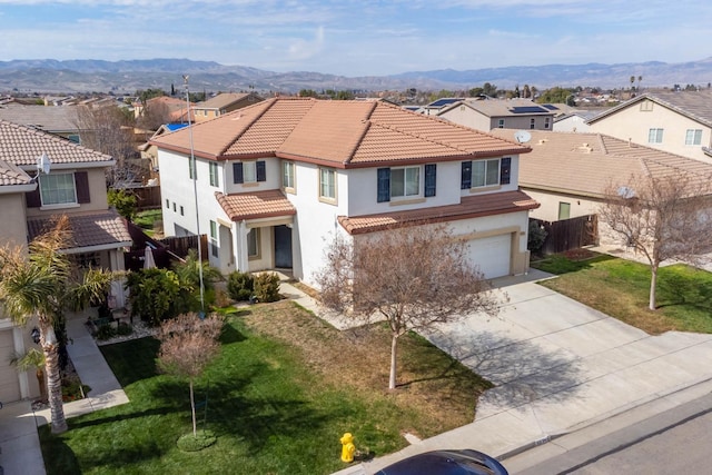 mediterranean / spanish-style house featuring a mountain view, a tiled roof, driveway, and a residential view