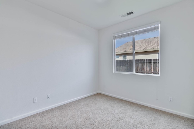 carpeted spare room with baseboards and visible vents