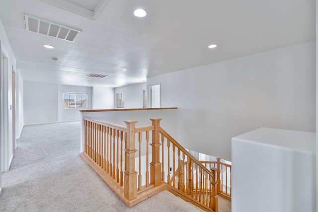 corridor with recessed lighting, visible vents, light carpet, and an upstairs landing