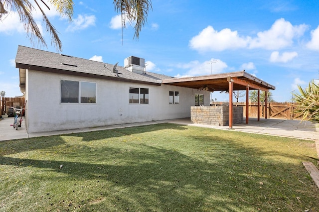 rear view of property with a patio, fence, a yard, roof with shingles, and stucco siding