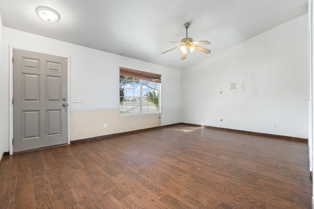 empty room with lofted ceiling, dark wood-type flooring, a ceiling fan, and baseboards