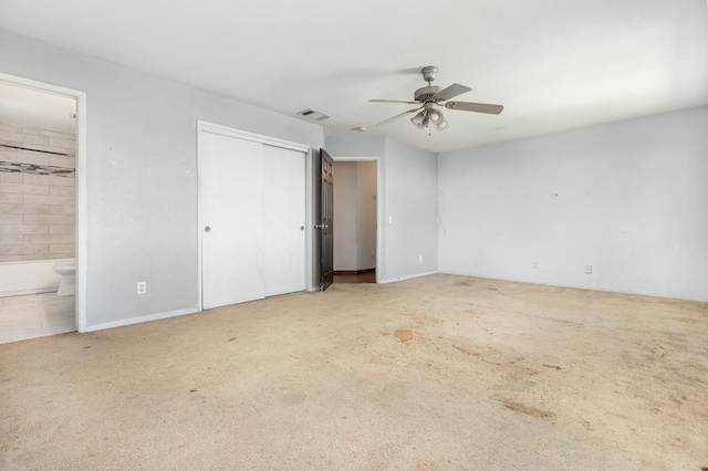 unfurnished bedroom with ensuite bath, visible vents, and carpet flooring