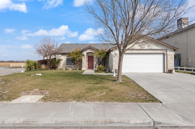 view of front of house with stucco siding, a front yard, fence, a garage, and driveway