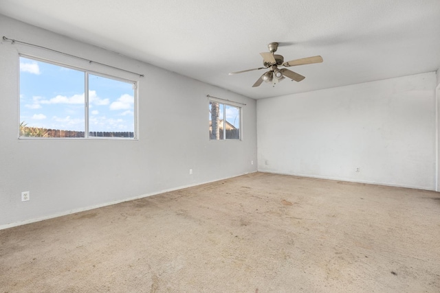 carpeted empty room featuring ceiling fan, a textured ceiling, and baseboards