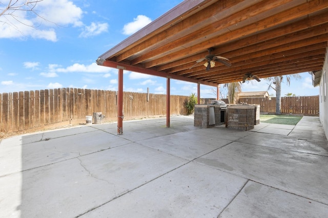 view of patio / terrace with exterior kitchen, a fenced backyard, and ceiling fan