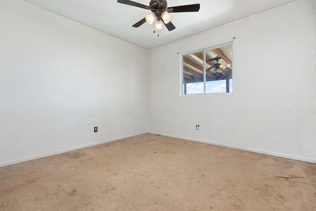 carpeted empty room with baseboards and a ceiling fan