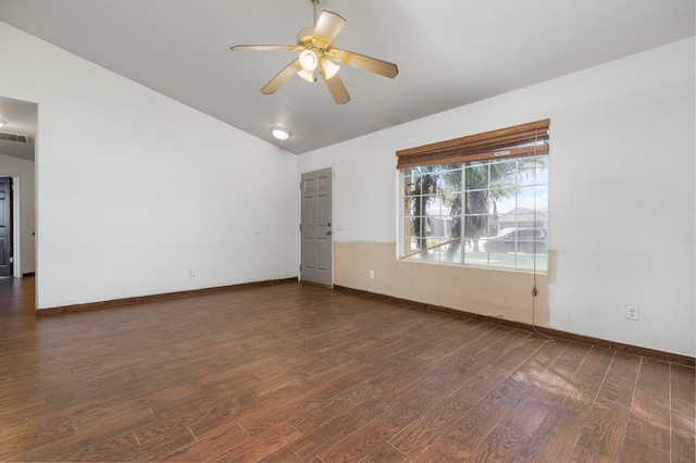 spare room featuring ceiling fan, visible vents, baseboards, vaulted ceiling, and dark wood-style floors