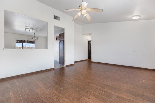 empty room with dark wood-style flooring, visible vents, vaulted ceiling, baseboards, and ceiling fan with notable chandelier