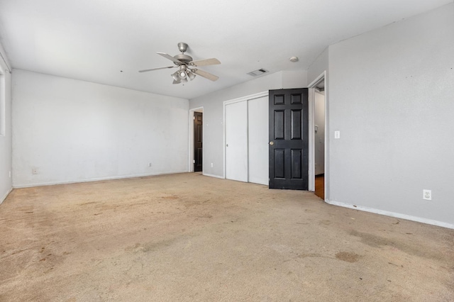 unfurnished bedroom with carpet, a closet, visible vents, ceiling fan, and baseboards