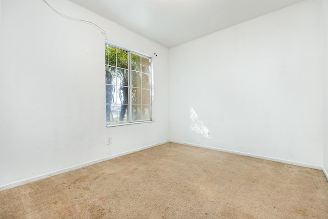 empty room featuring carpet floors and baseboards