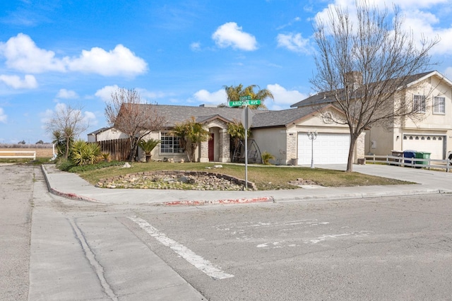 view of front of house with a garage, fence, concrete driveway, and stucco siding