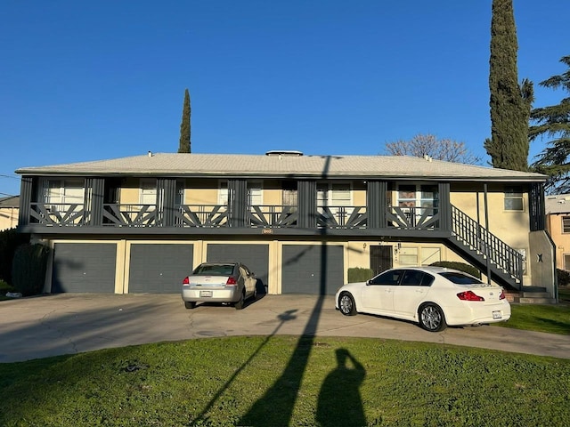 view of front of house with a garage, stairs, concrete driveway, and stucco siding