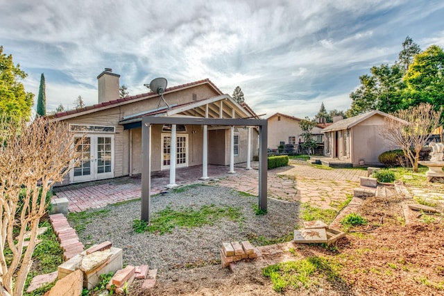 back of house with a patio, french doors, and a chimney