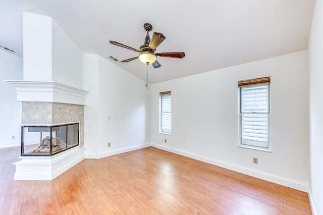 unfurnished living room with light wood-style floors, plenty of natural light, visible vents, and vaulted ceiling