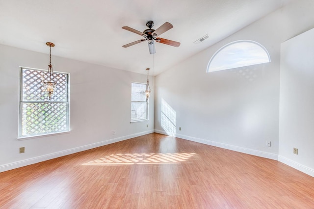 spare room featuring a ceiling fan, light wood-type flooring, visible vents, and baseboards