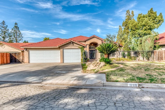 mediterranean / spanish house featuring an attached garage, a tile roof, fence, and stucco siding