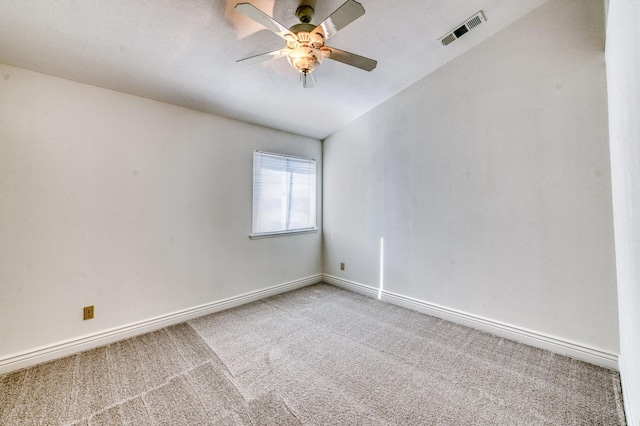 carpeted empty room featuring a ceiling fan, visible vents, a textured ceiling, and baseboards