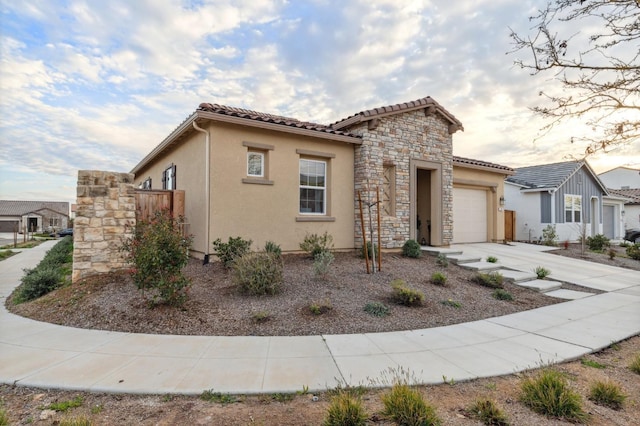 570 Laurel Crest Ave, Madera, CA 93636 - mediterranean / spanish-style house featuring an attached garage, stone siding, concrete driveway, and stucco siding