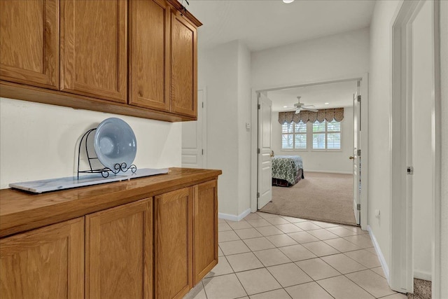 interior space featuring light tile patterned floors, wood counters, and brown cabinets