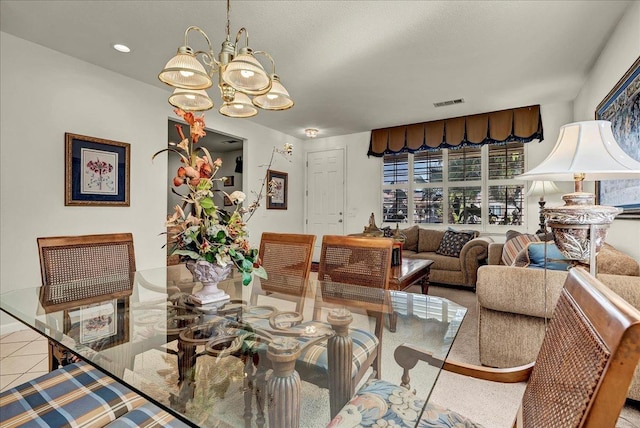 dining space with tile patterned floors, visible vents, and an inviting chandelier