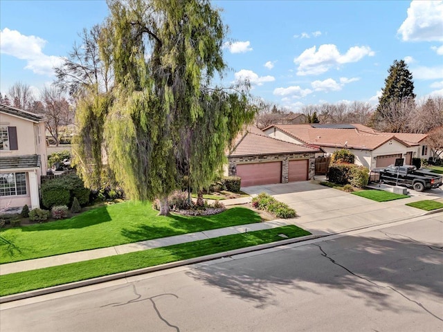 view of front of home with a garage, a front yard, and driveway