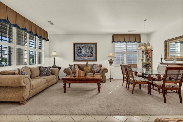 living area with light carpet, plenty of natural light, and visible vents