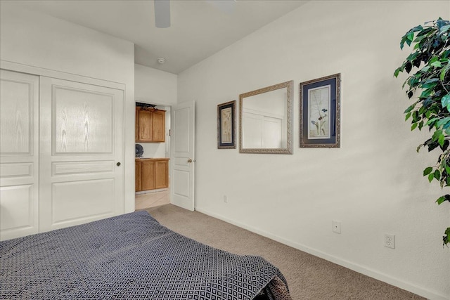 carpeted bedroom with a closet, baseboards, and a ceiling fan