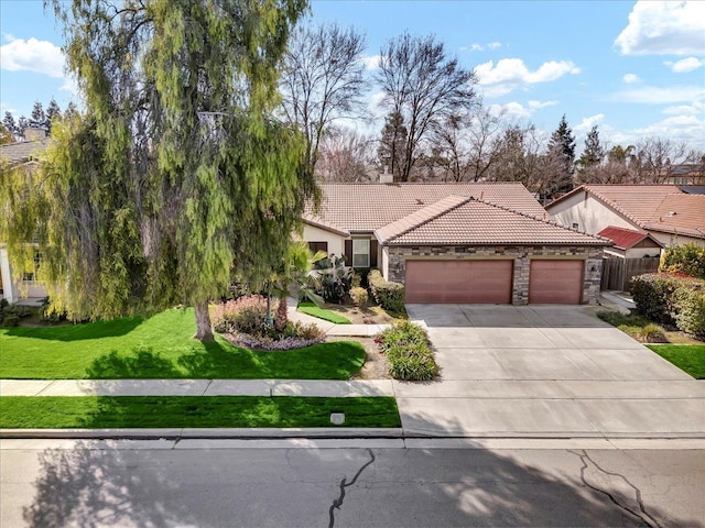 view of front facade featuring driveway, stone siding, a tile roof, an attached garage, and a front yard