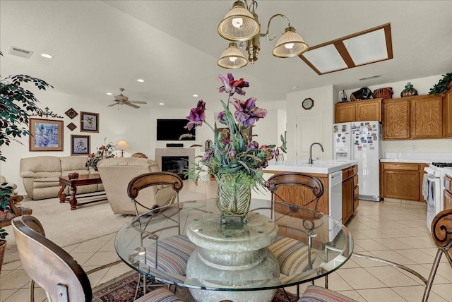 dining space featuring light tile patterned floors, visible vents, ceiling fan, a fireplace, and recessed lighting