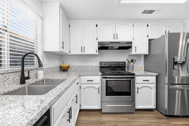 kitchen with visible vents, dark wood-type flooring, under cabinet range hood, a sink, and stainless steel appliances