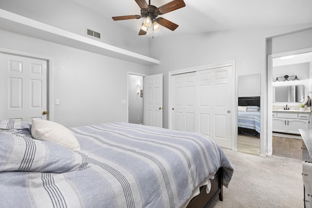 bedroom featuring a ceiling fan, visible vents, ensuite bath, vaulted ceiling, and light carpet