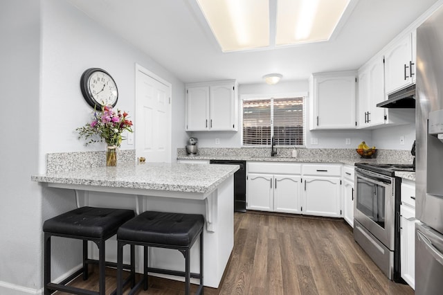 kitchen featuring under cabinet range hood, a breakfast bar area, stainless steel appliances, white cabinetry, and a sink