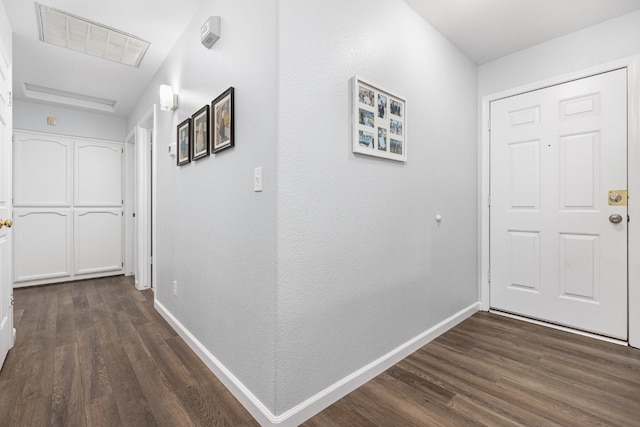 corridor featuring dark wood finished floors, visible vents, and baseboards