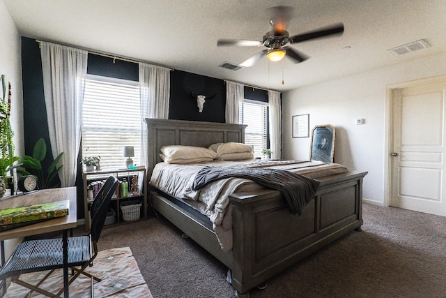 bedroom featuring a ceiling fan, visible vents, and dark carpet