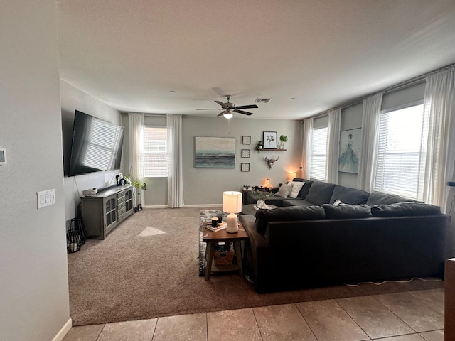 living room with carpet flooring, a ceiling fan, and baseboards