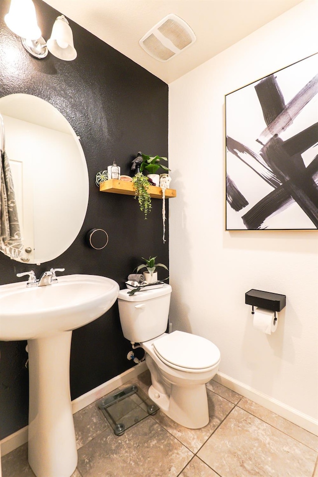 bathroom with toilet, a sink, visible vents, baseboards, and tile patterned floors