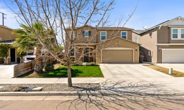 traditional-style house featuring driveway, stucco siding, and fence
