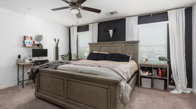 carpeted bedroom featuring baseboards, multiple windows, ceiling fan, and visible vents